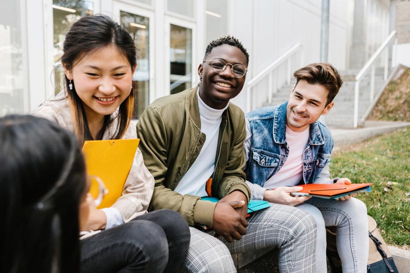 College-age students sit and talk on campus.